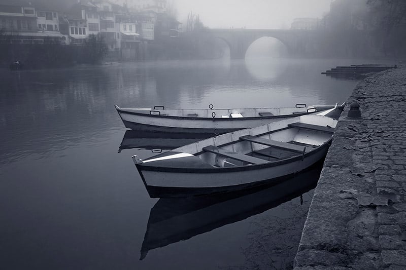 Monochromatic photo of two canoes